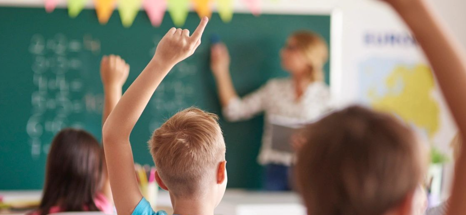 Classroom scene: students raising hands.